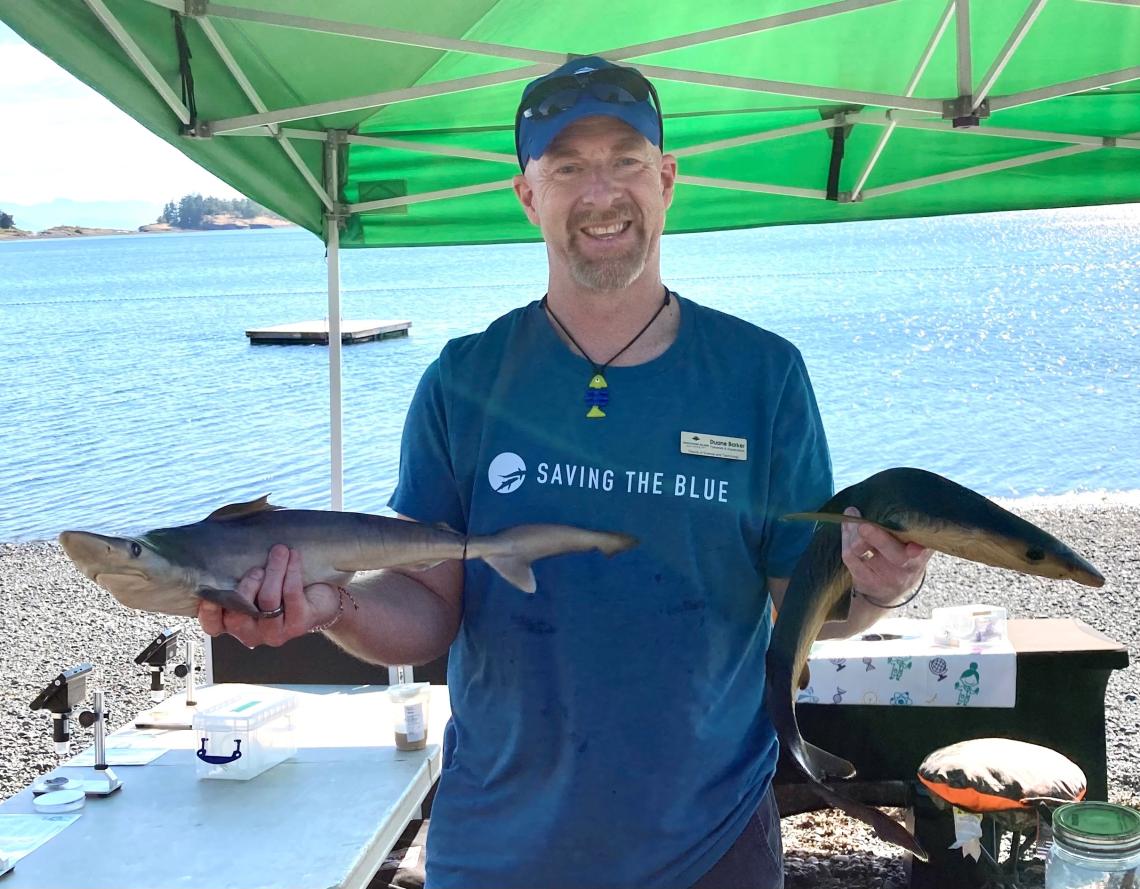 Dr. Duane Barker holding fish samples at the beach